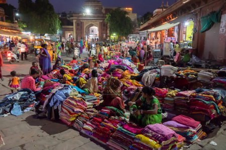 Photo for Jodhpur, Rajasthan, India - 19.10.2019 : Rajasthani womens clothes being sold at Famous Sardar Market and Ghanta ghar Clock tower in the evening. - Royalty Free Image