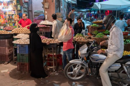 Photo for Jodhpur, Rajasthan, India - 18.10.2019 : Vegetables being sold to Muslim woman at famous Sardar Market and Ghanta ghar Clock tower in Jodhpur, Rajasthan, India. - Royalty Free Image