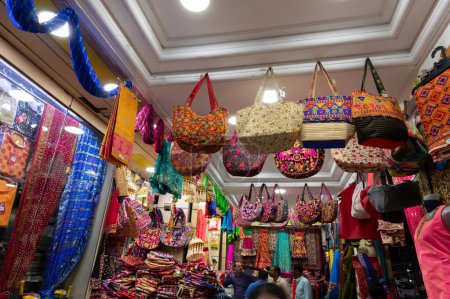 Photo for Jodhpur, Rajasthan, India - 19.10.2019 : Colorful Rajasthani ladies bags are displayed for sale at famous Sardar Market and Ghanta ghar Clock tower in Jodhpur, Rajasthan, India. - Royalty Free Image