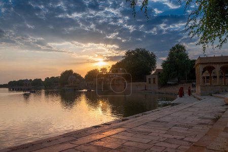 Photo for Sun sets behind main entrance of Gadisar lake, Jaisalmer, Rajasthan, India. Historical artifical lake, once only water resource for Jaisalmer city. - Royalty Free Image