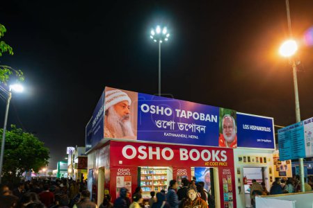 Téléchargez les photos : Kolkata, West Bengal, India - 2nd February 2020 : Colourful gate of a book stall at Kolkata Bookfair at night with full of book lovers . biggest bookfair in the world. - en image libre de droit