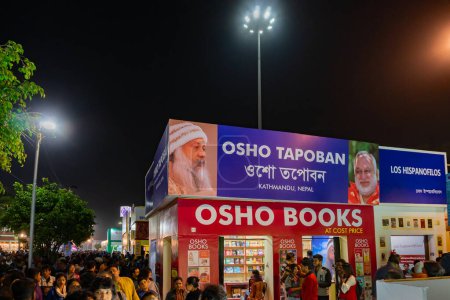 Téléchargez les photos : Kolkata, West Bengal, India - 2nd February 2020 : Colourful gate of a book stall at Kolkata Bookfair at night with full of book lovers . biggest bookfair in the world. - en image libre de droit
