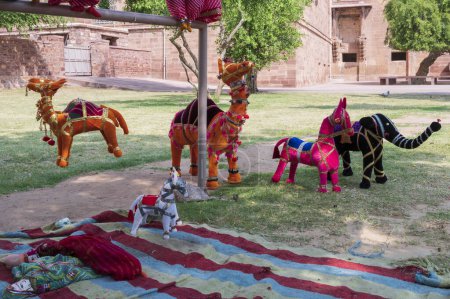 Photo for Hand made Rajasthani colourful dolls of Camel, horse and elephant displayed for sale at Mehrangarh Fort, Jodhpur, Rajasthan. Little dolls represent vibrant colors spread all across Rajasthan. - Royalty Free Image