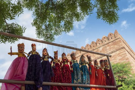 Photo for Traditional King and queen, called Raja Rani, handmade puppets or Katputli Sets are hanging for sale inside Meharangarh fort, Jodhpur, Rajasthan, India. Dolls in Jodhpur popular and sold to tourists. - Royalty Free Image