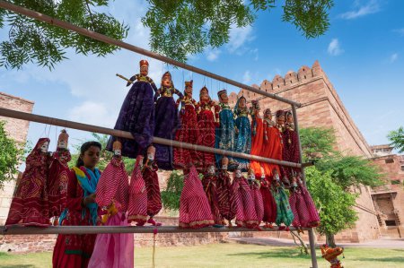 Photo for Jodhpur, Rajasthan, India - 19th October 2019 : Young Rajasthani woman selling hand made Rajaasthani colourful dolls of horse and elephant. Rajasthan is famous for its vibrant colors all across. - Royalty Free Image