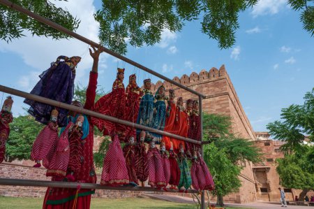 Photo for Traditional King and queen, called Raja Rani, handmade puppets or Katputli Sets are hanging for sale inside Meharangarh fort, Jodhpur, Rajasthan, India. Dolls in Jodhpur popular and sold to tourists. - Royalty Free Image