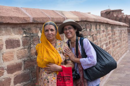 Photo for Jodhpur, Rajasthan, India - 17th October, 2019 : Happy Indian modern female solo traveller posing with traditional dressed old Rajasthani woman, at way to Chamunda Mataji temple of Mehrangarh fort. - Royalty Free Image