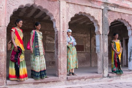 Foto de Jodhpur, Rajasthan, India - 19 de octubre de 2019: Hermosas mujeres Rajasthani de mediana edad posando vistiendo vestidos tradicionales de color rajasthani en el fuerte de Mehrangarh. Rajasthan está lleno de colores. - Imagen libre de derechos