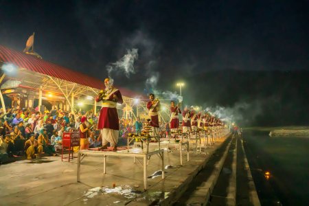 Téléchargez les photos : Tribeni Ghat, Rishikesh, Uttarakhand - 29 octobre 2018 : Ganga aarti interprété par des prêtres hindous aux chants des hymnes védiques. Le ghat le plus peuplé, le plus grand et le plus célèbre des rives du Gange. - en image libre de droit