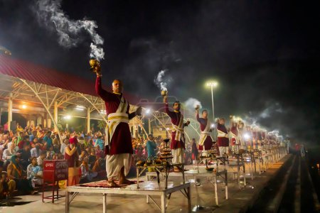 Téléchargez les photos : Tribeni Ghat, Rishikesh, Uttarakhand - 29 octobre 2018 : Ganga aarti interprété par des prêtres hindous aux chants des hymnes védiques. Le ghat le plus peuplé, le plus grand et le plus célèbre des rives du Gange. - en image libre de droit