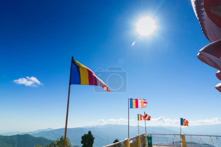 Téléchargez les photos : Drapeaux de prière bouddhistes colorés agitent dans le vent fort sous le soleil à Samdruptse, énorme monastère commémoratif bouddhiste au Sikkim, Inde. - en image libre de droit