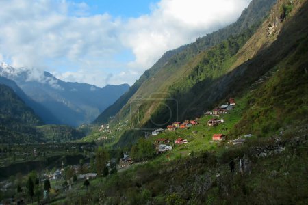 Foto de Juego de luces y sombras en Lachung, valle de Lachung, ciudad y una hermosa estación de la colina en el noreste de Sikkim, India. Montañas del Himalaya al fondo. Confluencia de los ríos Lachen y Lachung. - Imagen libre de derechos