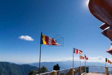 Téléchargez les photos : Drapeaux de prière bouddhistes colorés agitent dans le vent fort sous le soleil à Samdruptse, énorme monastère commémoratif bouddhiste au Sikkim, Inde. - en image libre de droit