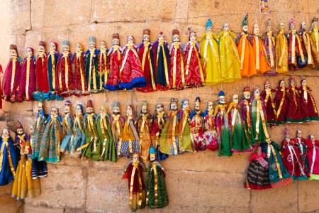 Foto de Fuerte Jaislamer, Rajastán, India - 13.10.2019: Rey y reina tradicionales, llamados Raja Rani, títeres hechos a mano o conjuntos Katputli cuelgan de la pared. Las muñecas en Jaisalmer son populares, se venden a los turistas. - Imagen libre de derechos