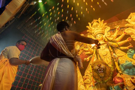 Foto de Howrah, Bengala Occidental, India - 3 de octubre de 2022: Sacerdotes hindúes adoran a la Diosa Durga con pradip. Ashtami puja aarati - sagrado Durga Puja ritual- festival del hinduismo que se realiza por la noche. - Imagen libre de derechos