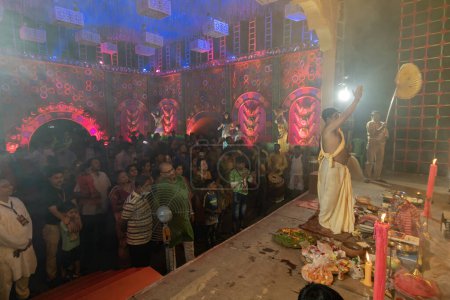 Photo for Howrah,West Bengal, India - 3rd October, 2022 : Hindu Bengali devotees praying to Goddess Durga while Purohit worshipping Goddess. Ashtami puja aarati - sacred Durga Puja ritual- festival of Hinduism. - Royalty Free Image