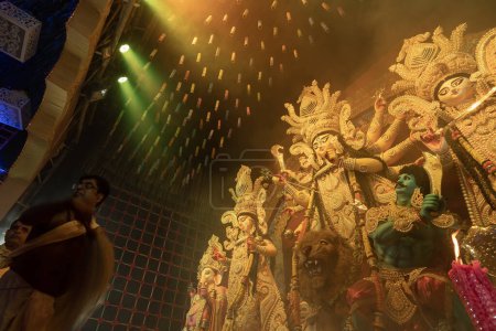 Téléchargez les photos : Howrah, Bengale occidental, Inde - 3 octobre 2022 : Prêtre hindou adorant la déesse Durga avec chamor, éventail de mouches. Ashtami puja aarati la nuit. Durga puja est patrimoine culturel immatériel de l'Unesco. - en image libre de droit