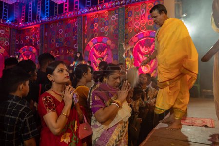 Photo for Howrah, West Bengal, India - 3rd October, 2022 : Hindu Bengali sari clad women praying to Goddess Durga inside Durga Puja pandal. Ashtami puja aarati at night. Biggest fetsival of Hinduism. - Royalty Free Image