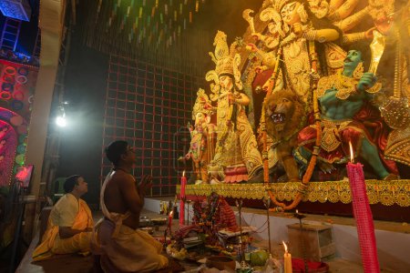 Photo for Howrah, West Bengal, India - 3rd October, 2022 : Hindu Priests praying and worshipping Goddess Durga inside Durga Puja pandal. Ashtami puja at night.Durga puja is unesco intangible cultural heritage. - Royalty Free Image