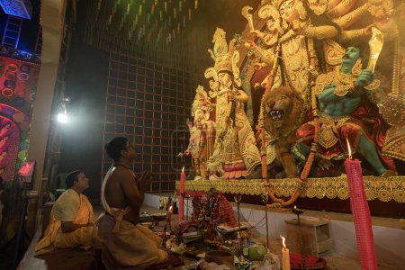 Photo for Howrah, West Bengal, India - 3rd October, 2022 : Hindu Priests praying and worshipping Goddess Durga inside Durga Puja pandal. Ashtami puja at night.Durga puja is unesco intangible cultural heritage. - Royalty Free Image