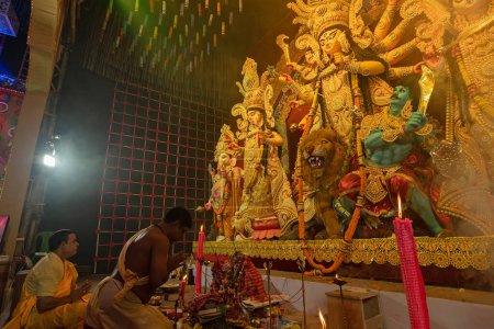 Photo for Howrah,West Bengal,India- 3rd October, 2022 : Hindu Priests praying and worshipping Goddess Durga with folded hands, kneels down position.Puja Pandal.Durga puja is unesco intangible cultural heritage. - Royalty Free Image