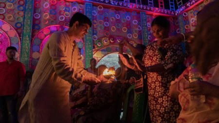 Foto de Howrah, Bengala Occidental, India - 5 de octubre de 2022: Los devotos hindúes comparten las bendiciones divinas de la Diosa Durga de la llama del fuego del Santo Panchapradip. Festival de Durga Puja, celebrado en todo el mundo. - Imagen libre de derechos
