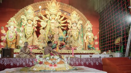 Foto de Howrah, Bengala Occidental, India - 5 de octubre de 2022: Vog, comida sagrada decorada ofrecida a la Diosa Durga, purohits hindúes organizando puja en el fondo.Ritual de Durga Puja.. - Imagen libre de derechos