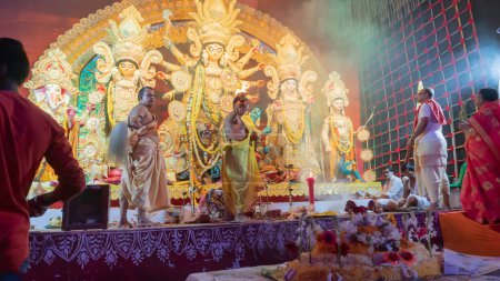 Foto de Howrah, Bengala Occidental, India - 5 de octubre de 2022: Dhaakis jugando a los dhaaks para adorar a la Diosa Durga, mientras que a la Diosa se le ofrece Vog, comida dulce santa. Un ritual sagrado de Durga Puja dentro de la puja pandal. - Imagen libre de derechos