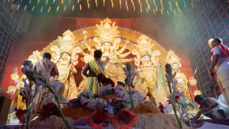 Photo for Howrah, West Bengal, India - 5th October, 2022 : Hindu Purohits offering Vog, holy sweet food for Goddess Durga while worshipping her inside Durga puja pandal covered with holy smoke. - Royalty Free Image