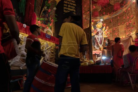 Téléchargez les photos : Howrah, Bengale occidental, Inde - 3 octobre 2022 : Dhaakis jouant aux dhaaks pour adorer la déesse Durga. Un rituel sacré de Durga Puja. pandal décoré pour la déesse Durga, plus grand festival de l'hindouisme. - en image libre de droit