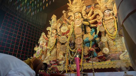 Photo for Howrah,West Bengal,India-5th October, 2022 : Hindu Purohit showing respect, praying and worshipping Goddess Durga, kneels down position. Puja Pandal. Durga puja is unesco intangible cultural heritage. - Royalty Free Image