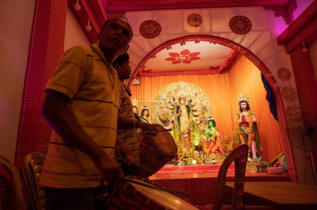 Foto de Howrah, Bengala Occidental, India - 3 de octubre de 2022: Dhaakis jugando dhaaks para adorar a la Diosa Durga. Un ritual sagrado de Durga Puja. pandal decorado para la diosa Durga, el mayor festival del hinduismo. - Imagen libre de derechos
