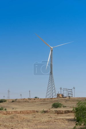 Photo for Blue desert sky and Electrical power generating wind mills producing alterative eco friendly green energy for consumption by local people.Thar desert,Rajasthan,India.Environment friendly power source. - Royalty Free Image