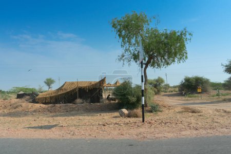 Un remoto pueblo desértico dentro del desierto. horizonte lejano, verano caliente con el fondo azul claro sin nubes del cielo, desierto de Thar, Rajasthan, India.