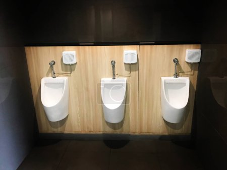 Photo for Closeup white urinal in men's bathroom., Men's toilets room with white porcelain urinals in line. - Royalty Free Image