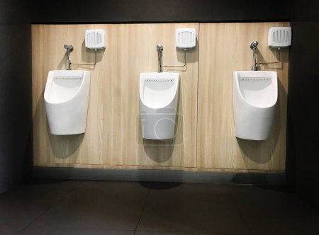 Photo for Closeup white urinal in men's bathroom., Men's toilets room with white porcelain urinals in line. - Royalty Free Image