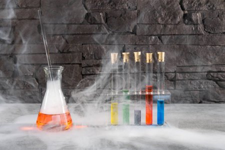 Foto de Frascos químicos con fluidos de colores y niebla alrededor - Imagen libre de derechos