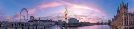 Foto de London, England, UK - January 11, 2023: Panoramic view of the Westminster Bridge, Parliament House and London Eye illuminated at sunrise - Imagen libre de derechos