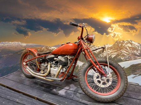 Hermosas vistas panorámicas de una vieja motocicleta vintage en una cresta de montaña al atardecer. 