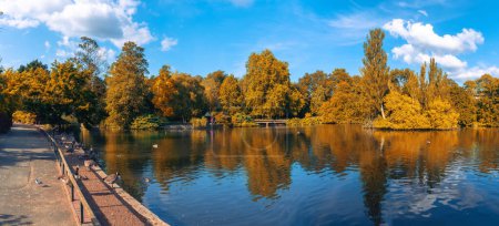 Téléchargez les photos : Vue panoramique du parc public Kelsey avec des arbres à feuillage reflétés dans le lac à l'automne - Beckenham village, Londres - en image libre de droit