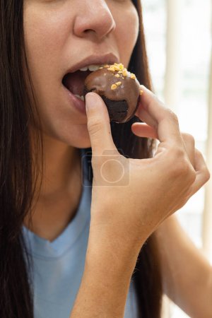 Foto de Morder para comer una trufa de chocolate, estilo de vida y comida dulce, confitería dulce como fondo de pantalla, delicia apetitosa - Imagen libre de derechos