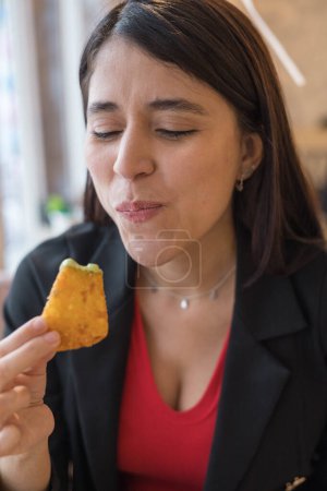 Foto de Joven mujer tomando un bocado de una pepita frita, estilo de vida y belleza natural de modelo femenino, disfrutando de la comida, comida rápida - Imagen libre de derechos