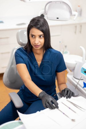 Téléchargez les photos : Dentiste préparer les instruments médicaux pour prendre soin des patients dans son cabinet dentaire, mode de vie professionnel de la santé - en image libre de droit