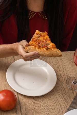 Foto de Tomar un bocado de un pedazo de pizza, apetecible comida rápida como fondo de pantalla en el estudio, alimentación poco saludable, comida - Imagen libre de derechos