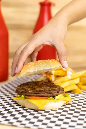Foto de Fondo de pantalla, montaje de una hamburguesa clásica con carne, queso y verduras, preparación de comida rápida, ingredientes frescos y deliciosos, fondo de pantalla de fotos de estudio - Imagen libre de derechos