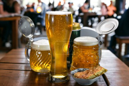 Téléchargez les photos : La bière dans un verre à bière et dans des tasses à bière se tient sur une table dans un café. Bière. - en image libre de droit