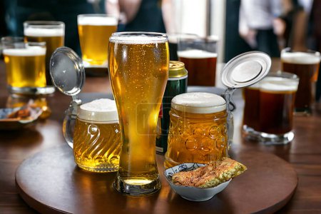 Téléchargez les photos : Des bières dans des verres à bière et des tasses à bière sont sur les tables du pub. Bière. - en image libre de droit