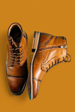 Un par de botas de piel de becerro premium sobre un fondo marrón. Disparo vertical. Ideas de zapatos para hombres.
