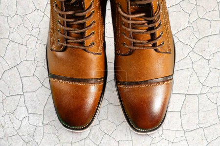 Un par de botas de piel de becerro premium sobre un fondo de piedra. Disparo horizontal. Ideas de zapatos para hombres.