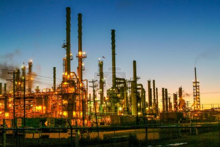 Petroleum oil refinery at sunset with lights on  